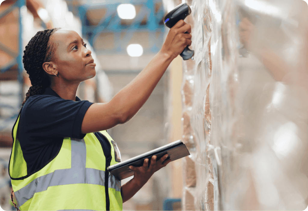 an employee in a warehouse using cloud-based transport management systems to effectively streamline shipping processes