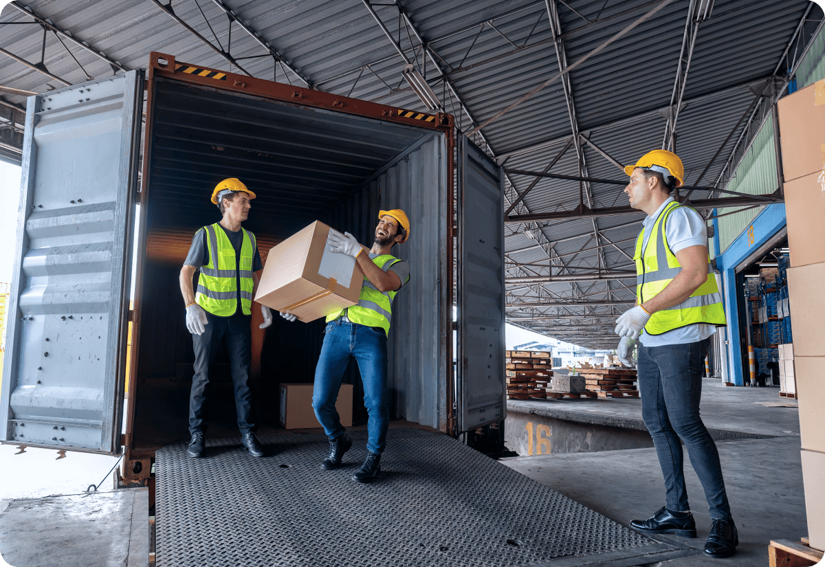 warehouse workers carrying a package demonstrating good freight load strategy