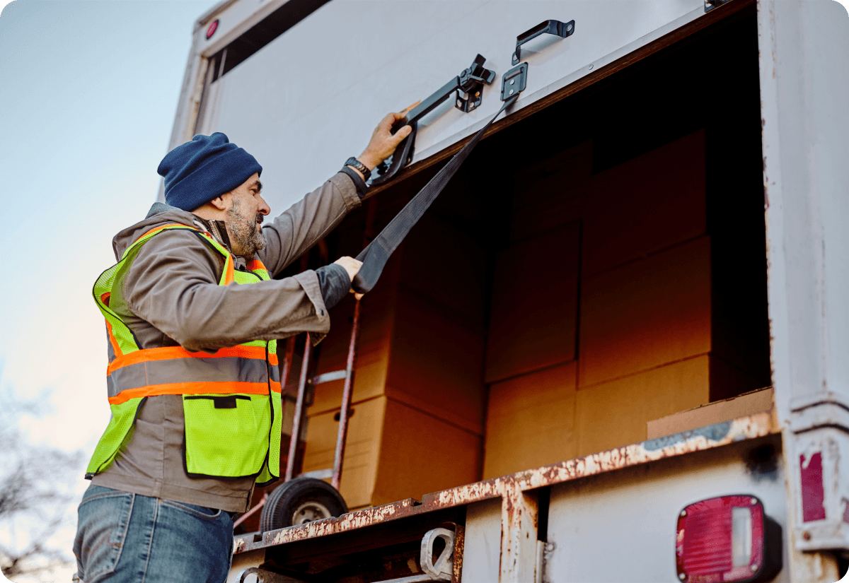deliver man from one of the best order fulfillment companies in usa checking on parcels from warehouse in his truck