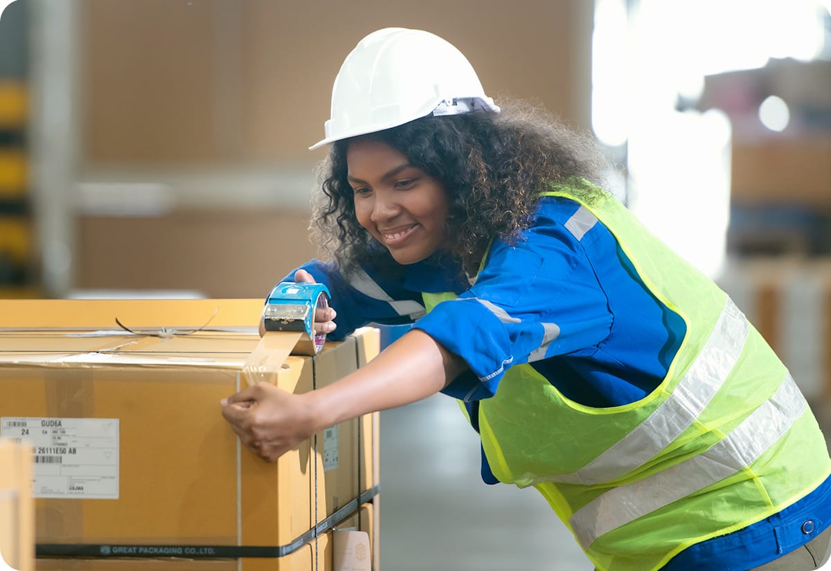 a warehouse worker securing a package as part of the fragile shipping process