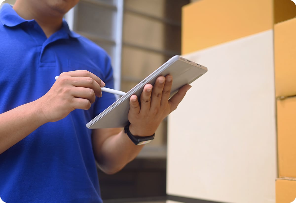 warehouse worker checks for shipping rate analytics via device