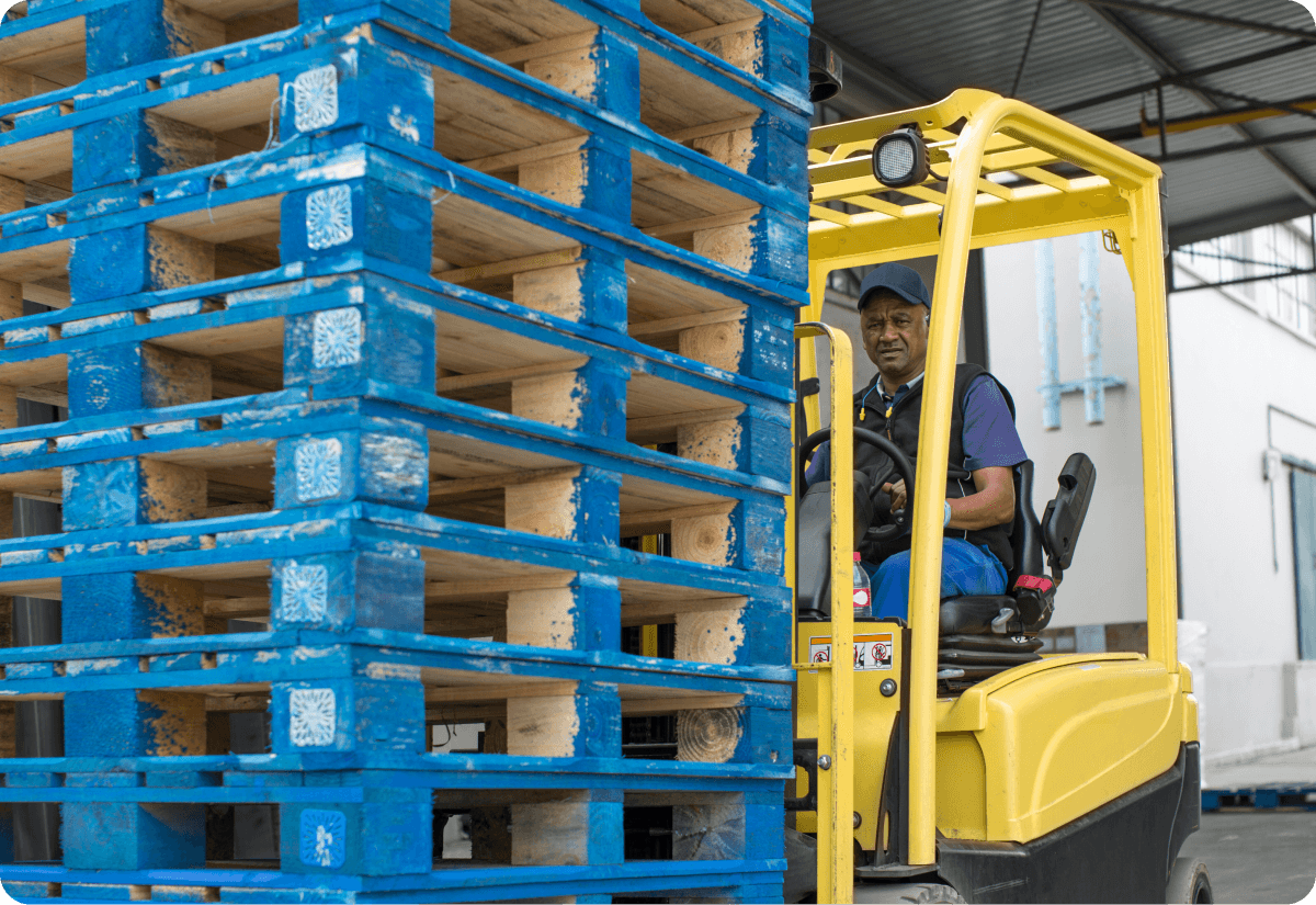 Warehouse worker moving pallets in a logistics hub