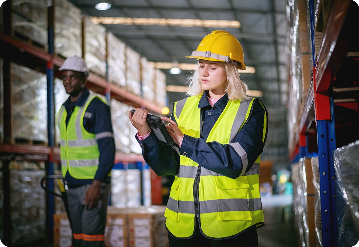 Female manager conducting inventory analysis in a warehouse full of parcels