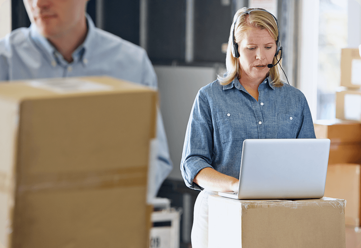 Employee working on a laptop, managing logistics data collection and organizing supply chain information
