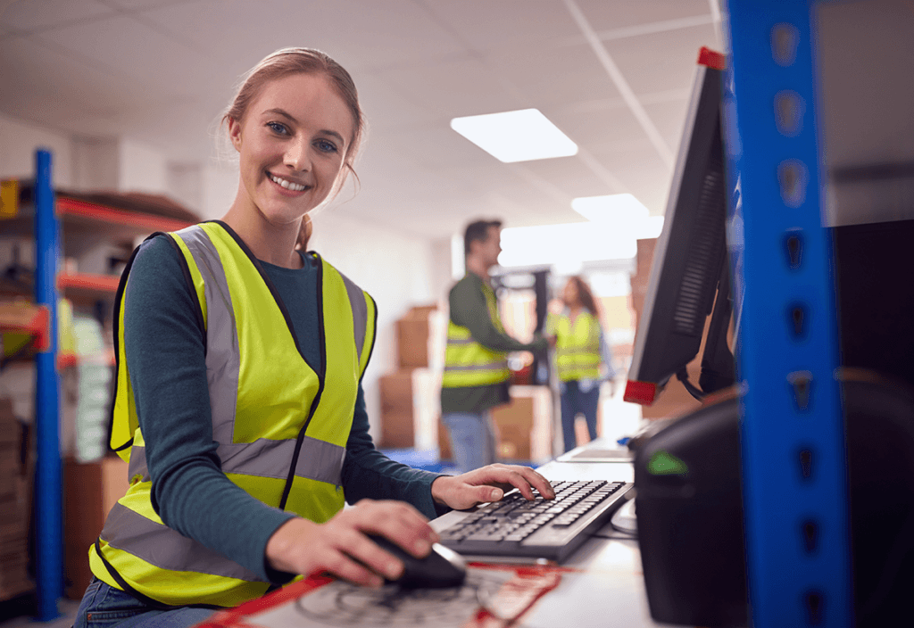 Employee working at a computer, reviewing shipment analytics for data-driven logistics tracking