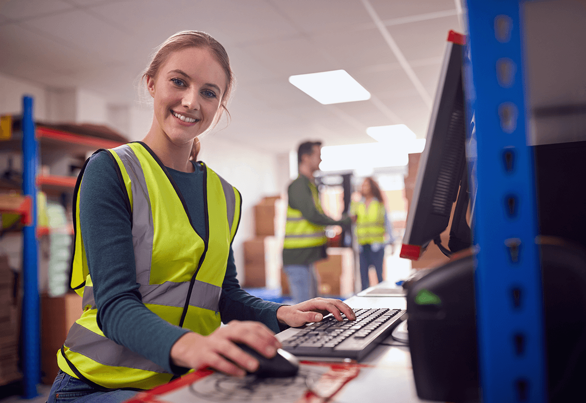 Employee working at a computer, reviewing shipment analytics for data-driven logistics tracking