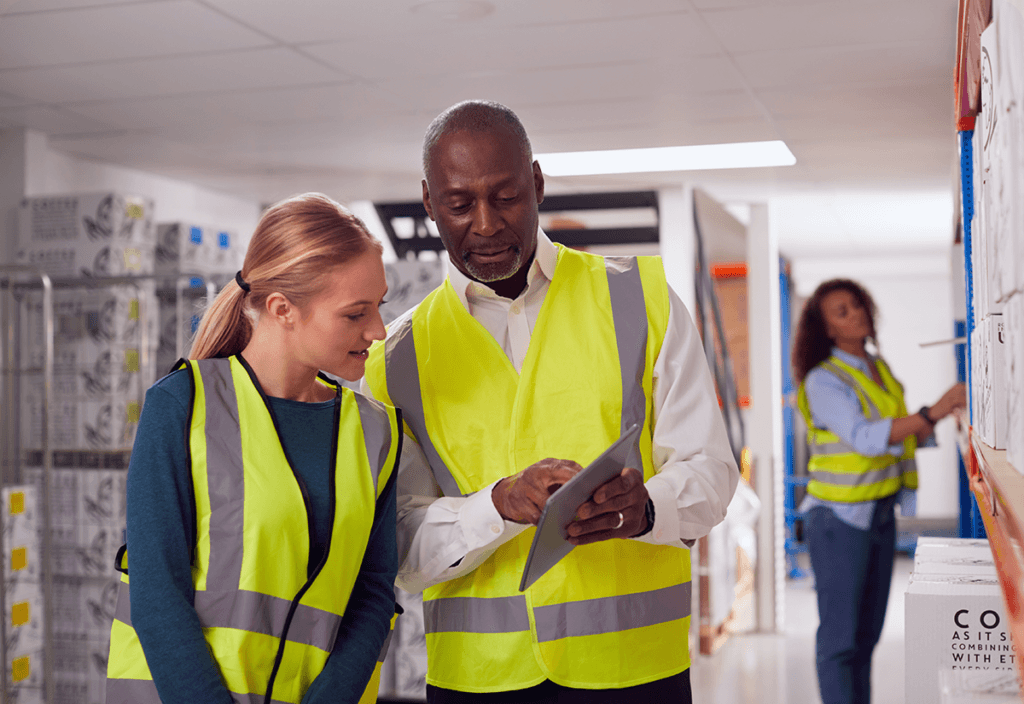 Two employees reviewing freight service details on a tablet and contract information before signing