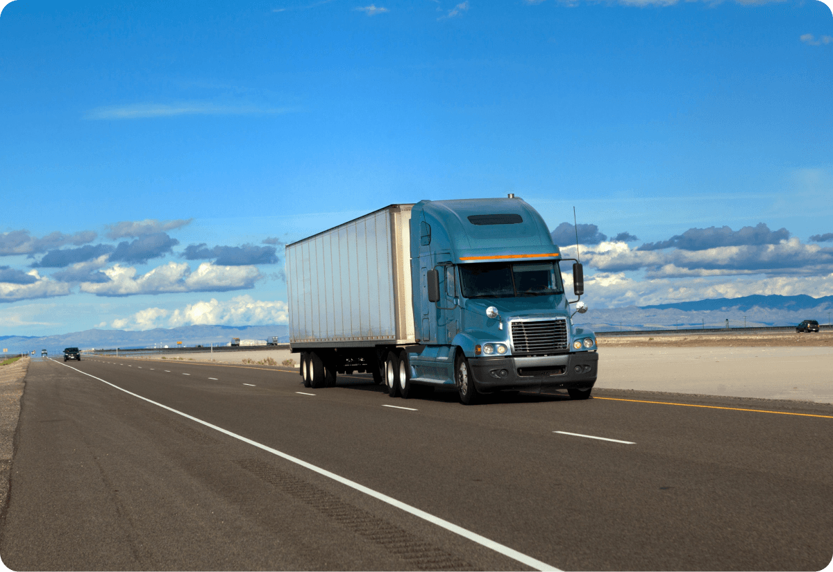 A truck driving on a long highway to maintain carrier capacity.