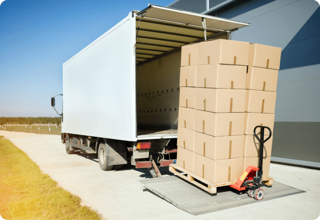 Inbound logistics with a truck unloading boxes onto a pallet jack at a warehouse receiving dock.