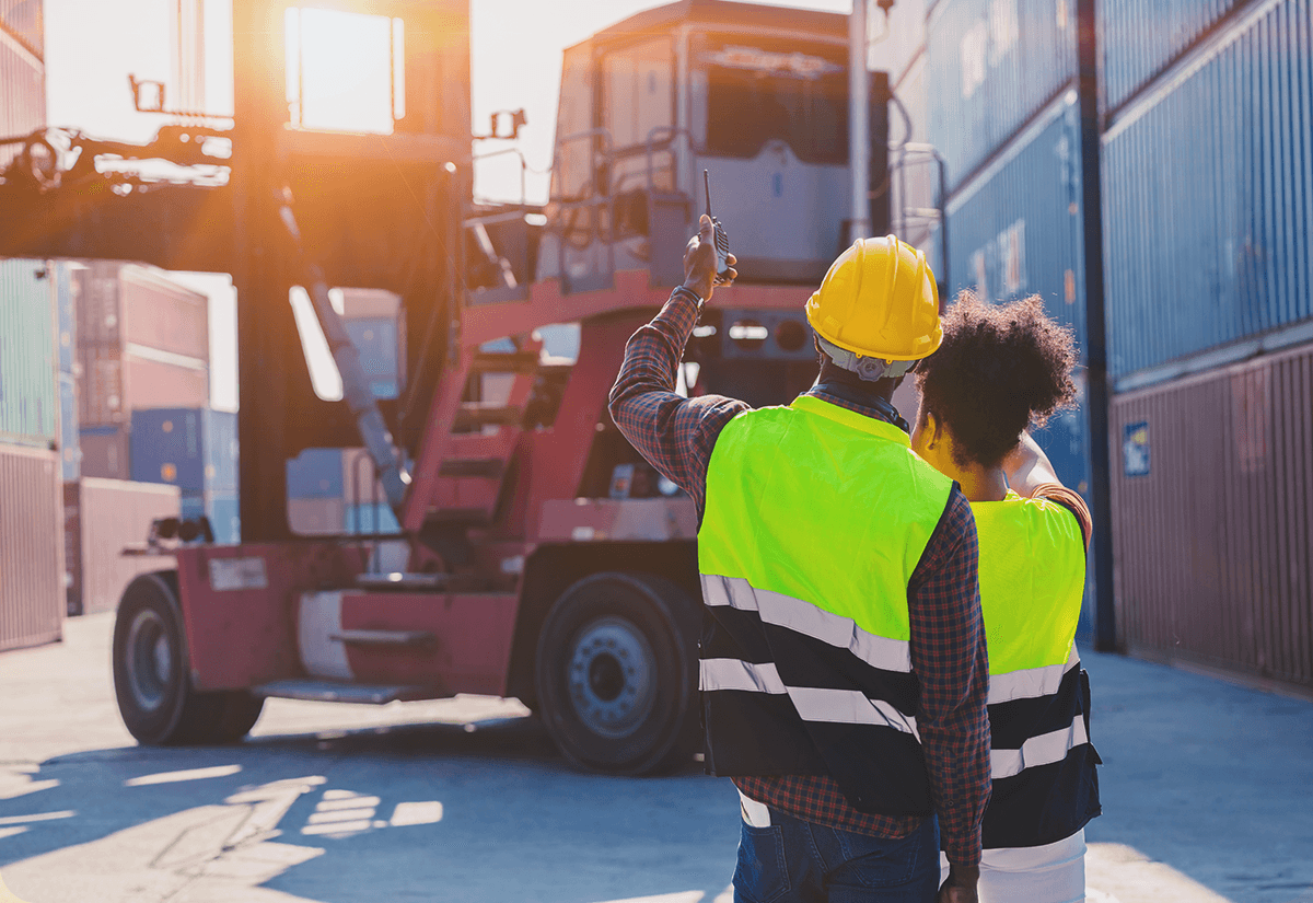 Warehouse employees monitoring forklift operations for freight consolidators.