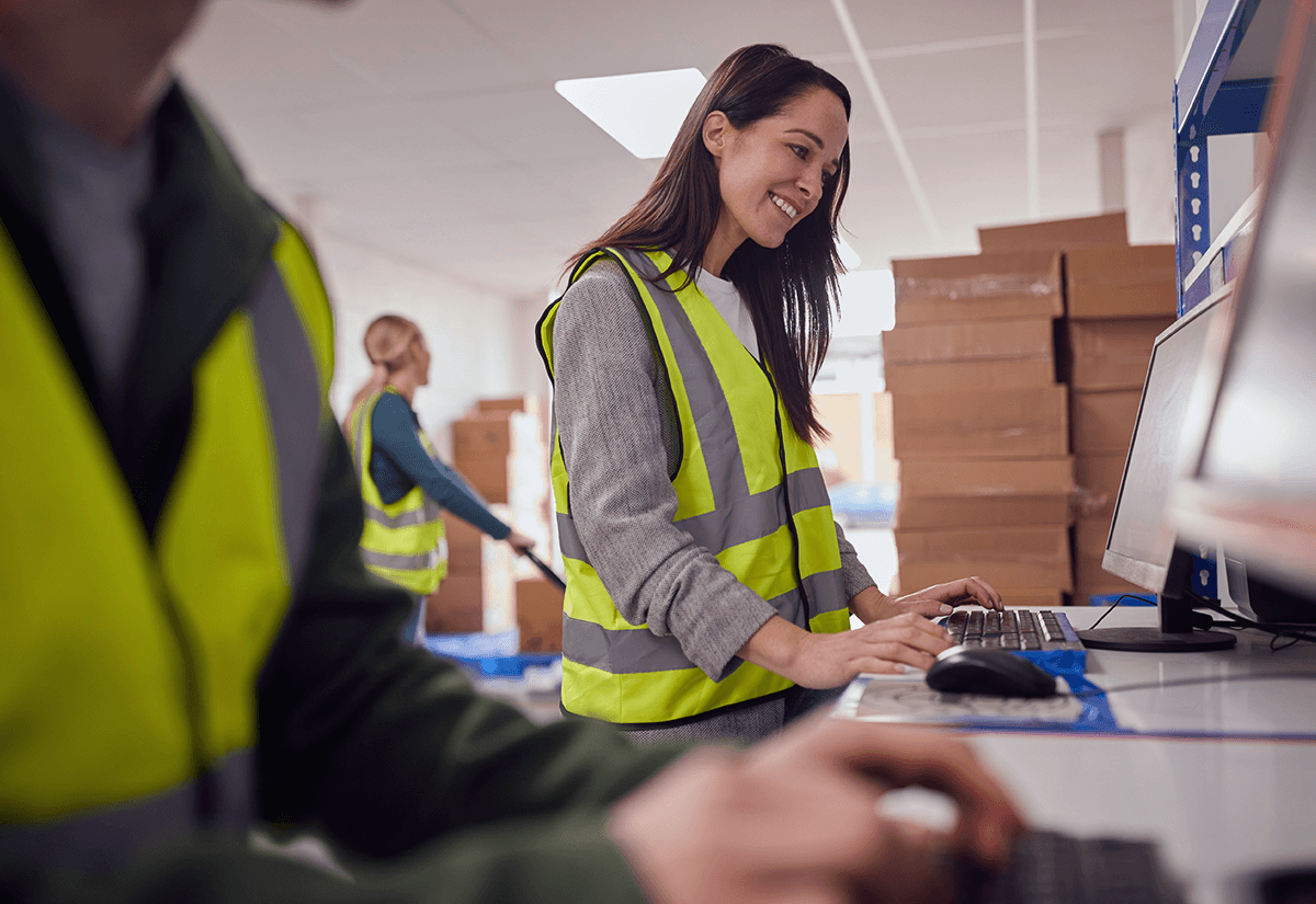 Employee monitoring shipment data on a computer to improve transportation visibility.