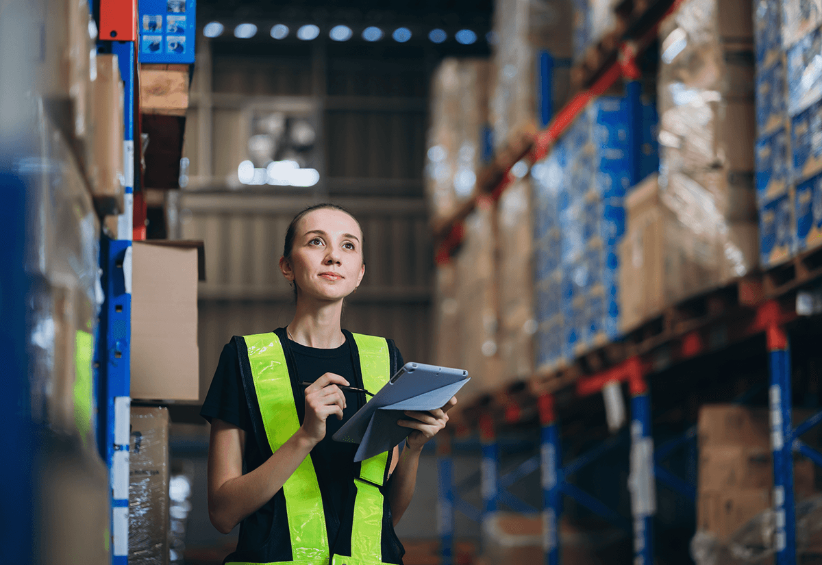 Warehouse worker reviewing shipment data on a tablet for accurate freight billing.
