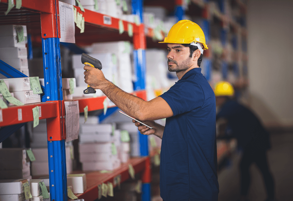 Warehouse worker scanning products for inventory management in supply chain operations.
