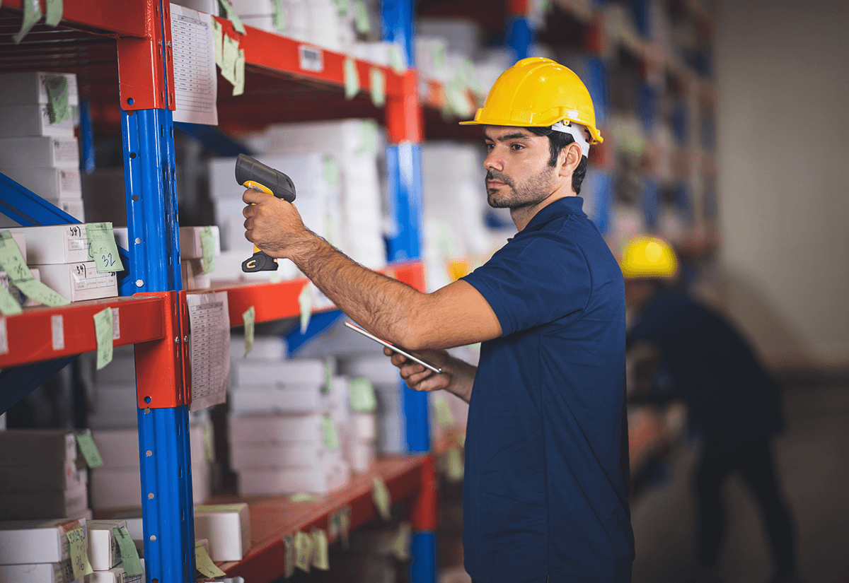 Warehouse worker scanning products for inventory management in supply chain operations.
